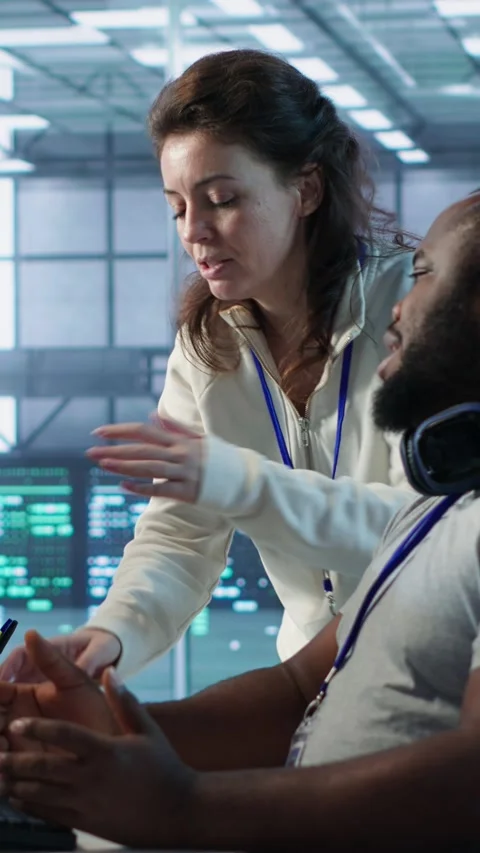 Team leader teaching IT specialist how to while monitor AI supercomputers Stock Footage 319576219