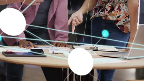 Team leaning over table, tapping tablet and activating node overlay on docs, Video stock 333704993