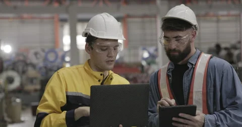 Team of machinery factory engineers uses laptops to inspect machines Stock Footage 254459448
