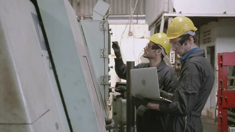 Team maintenance engineer using laptop computer control machine in factory to Stock Footage 142485262
