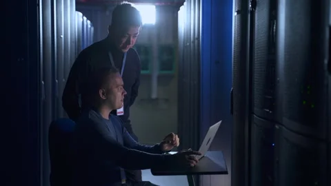 Team of male engineers discussing IT project and working with laptop in big data Stock Footage 166837548
