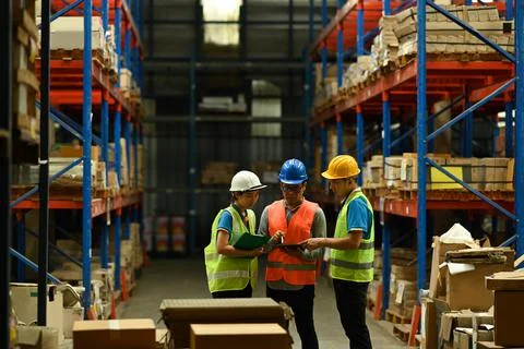Team of manager using digital tablet while standing between retail warehouse Foto stock