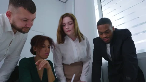 Team of managers bending over table to discuss plan Stock Footage 155502890