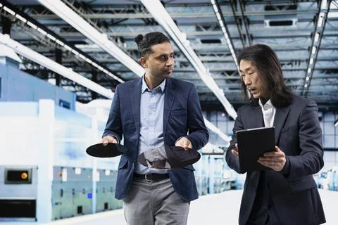 Team of managers using tablet to analyze semiconductor substrates Stock Photos