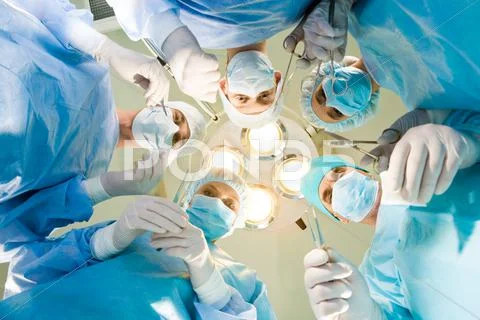 Team of medical staff with surgical instruments looking at camera Stock Photos