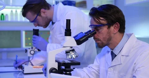 Team of Medical Students Working on Microscope Laboratory Researching Diseases Stock Footage
