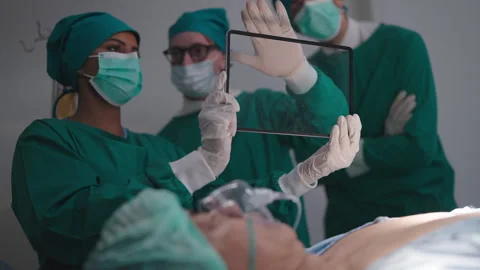 Team of medical using and touching on digital screen, for treatment a patient's. Video stock 243892597