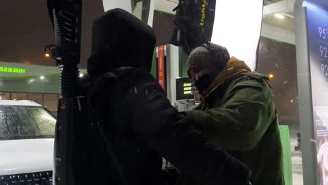 Team member straps steadicam on operator in snowy conditions Stock Footage 308939746