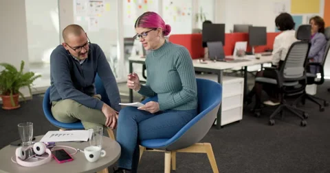 Team members collaborate in an office setting discussing ideas and strategies Stock Footage 338035696