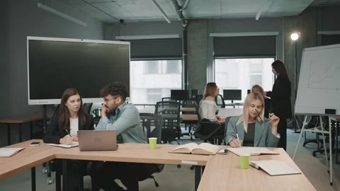 Team members collaborate in an office space while working on projects 動画素材 326325586