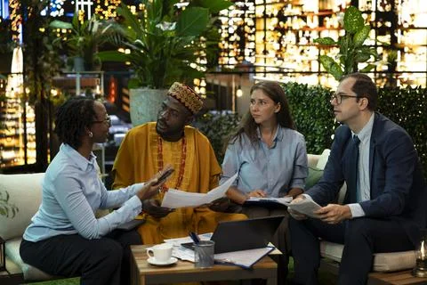 Team members evaluate strategy notes in city workspace late at night Stock Photos