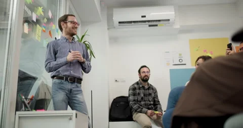 Team members share ideas during a meeting in an office, fostering collaboration Stock Footage 324884455