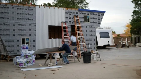 A team of men construction workers building a tiny house and installing Stock Footage 120755706