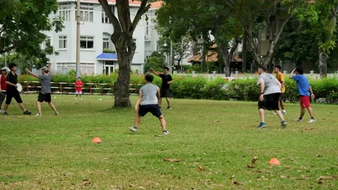 Team of men run around playing frisbee as outdoor activity in the park for fun Stock Footage 150786426