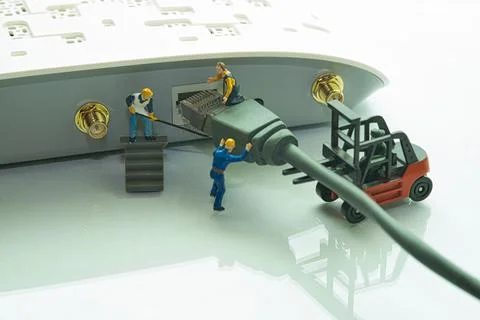 Team of miniature figures connects a data cable in an internet Stock Photos