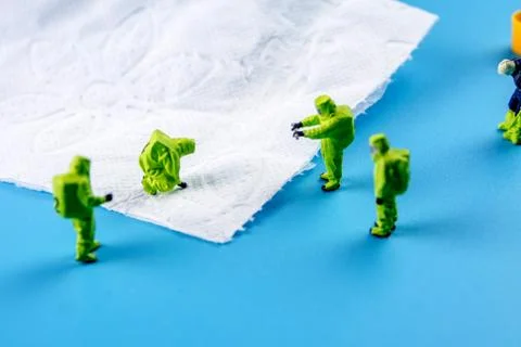 A team of miniature figurines checking a cleanliness of toilet paper as a sym Foto stock