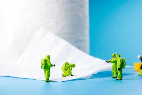 A team of miniature figurines checking a cleanliness of toilet paper as a sym Stock Photos
