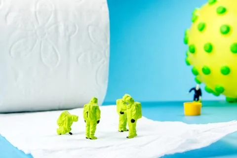 A team of miniature figurines checking a cleanliness of toilet paper as a sym Stock Photos