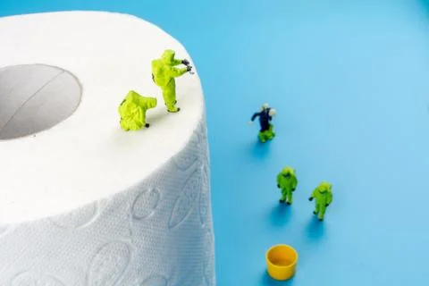 A team of miniature figurines checking a cleanliness of toilet paper as a sym Stock Photos
