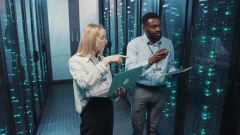 Team of mixed-race server administrators cooperating checking working server Stock Footage 119082265