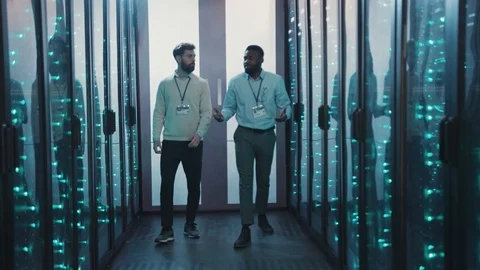 Team of multi-ethnic IT engineers having nice convsersation while walking along Stock Footage 119081413
