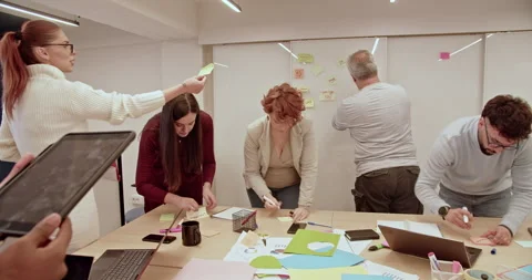 Team of multi generational, creative people brainstorming on a project with Stock Footage 271213406