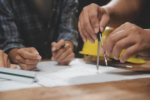 Team of multiethnic architects working on construction plans in meeting roo.. Stock Photos