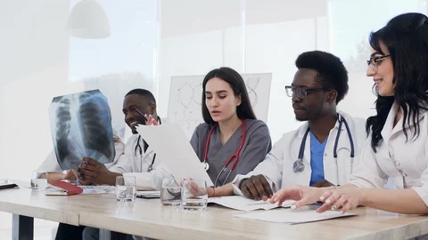 Team of multiethnic young doctors having a meeting in conference room in the Stock Footage 105977022