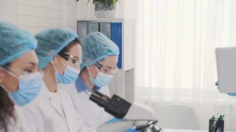 A team of multinational laboratory technicians, an African American conducts Stock Footage 230454580
