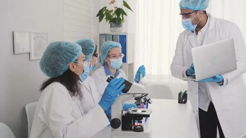 A team of multinational laboratory technicians, an African American conducts Stock Footage 230460846