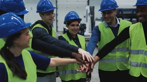 Team of multiracial engineers stacking hands together inside robotic factory Stock Footage 198370008