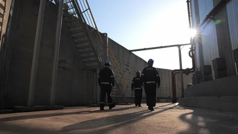 Team of oil industry workers inspects the fuel tanks of a large refinery at dawn 動画素材 212384565