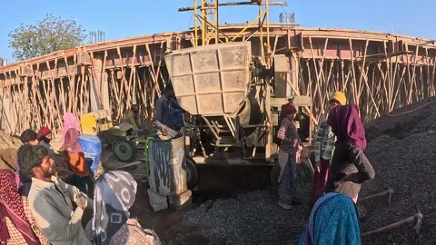 Team Operating Concrete Mixer at Active Building Site for Infrastructure Stock Footage 337790037