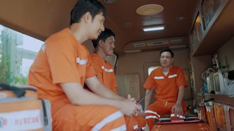 Team paramedic talking together during breaks from work sitting in an ambulance. Stock Footage 265555430