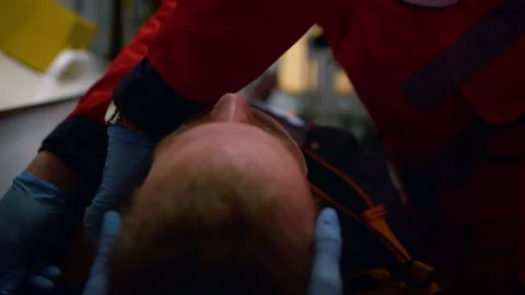 Team of paramedics in gloves performing first aid procedure in emergency vehicle Stock Footage 166906050