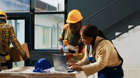 Team of people using racks to stack cardboard boxes Stock Photos