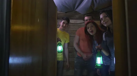 Team of players amazed about finding a secret entrance in escape room game Stock Footage 68827134