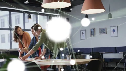 Team pointing at docs, sparking glowing node network flaring then dimming, Stock-Footage 333336189