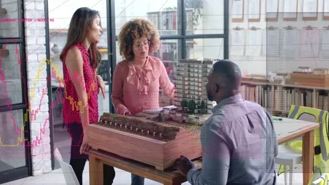 Team pointing at scale model, causing chart overlays sliding in, inspecting for Stock Footage 333336170