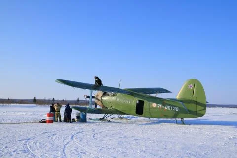 The team is preparing the An-2 plane for takeoff among the tundra in the Nort Fotos de archivo