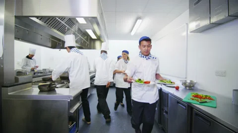 Team of professional chefs preparing food in a commercial kitchen Stock Footage 31870540