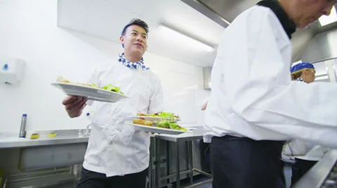 Team of professional chefs preparing food in a commercial kitchen Stock Footage 31870913