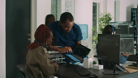 Team of programmers analyzing coding algorithms on laptop and computer 動画素材 221750074