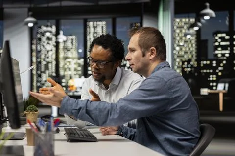 Team of programmers brainstorming in office, reviewing AI system metrics Stock-Fotos