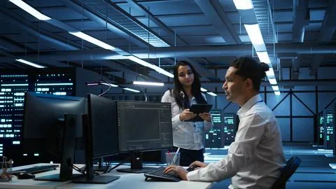 Team of programmers in high tech data center troubleshooting issues Foto stock