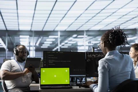 Team of programmers in server farm using green screen laptop 스톡 사진