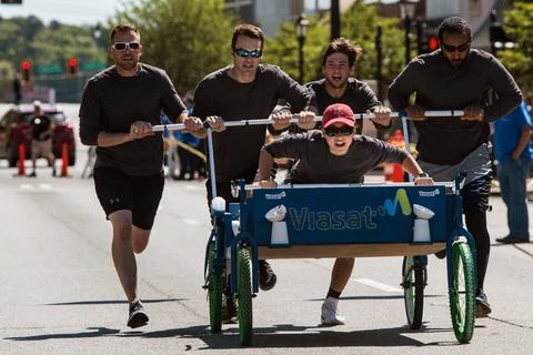 Team Pushes Bed Down Street In Charity Fundraiser Race Event Stock-Fotos