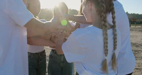 The team put their hands together to combine forces Stock Footage 148394349