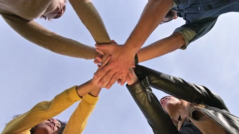 The team puts their hands together and shakes against the sky. Unity conception Stock Footage 143618672