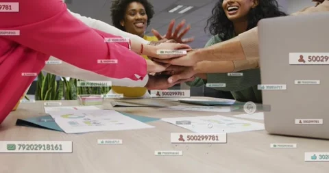 Team reaching across business table forming hand stack, showing data tags on 库存影片 334182717